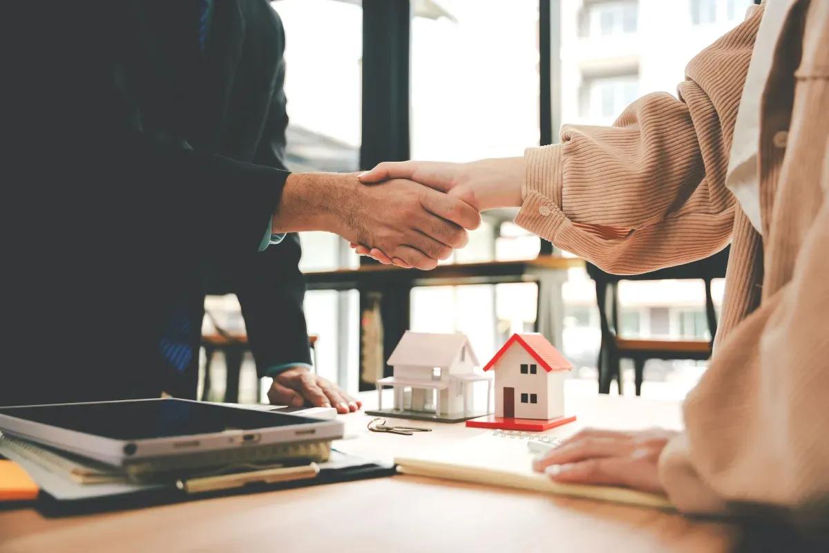A man and a woman are shaking hands over a table