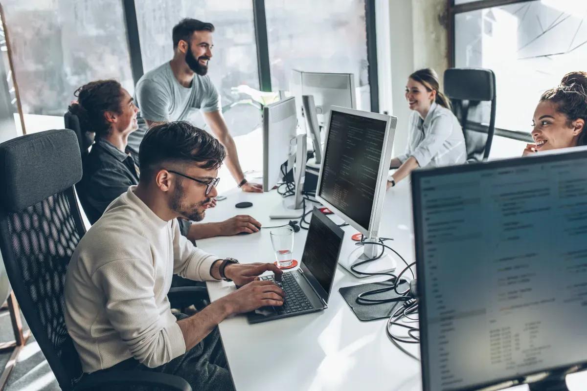A group of people are working on computers in an office