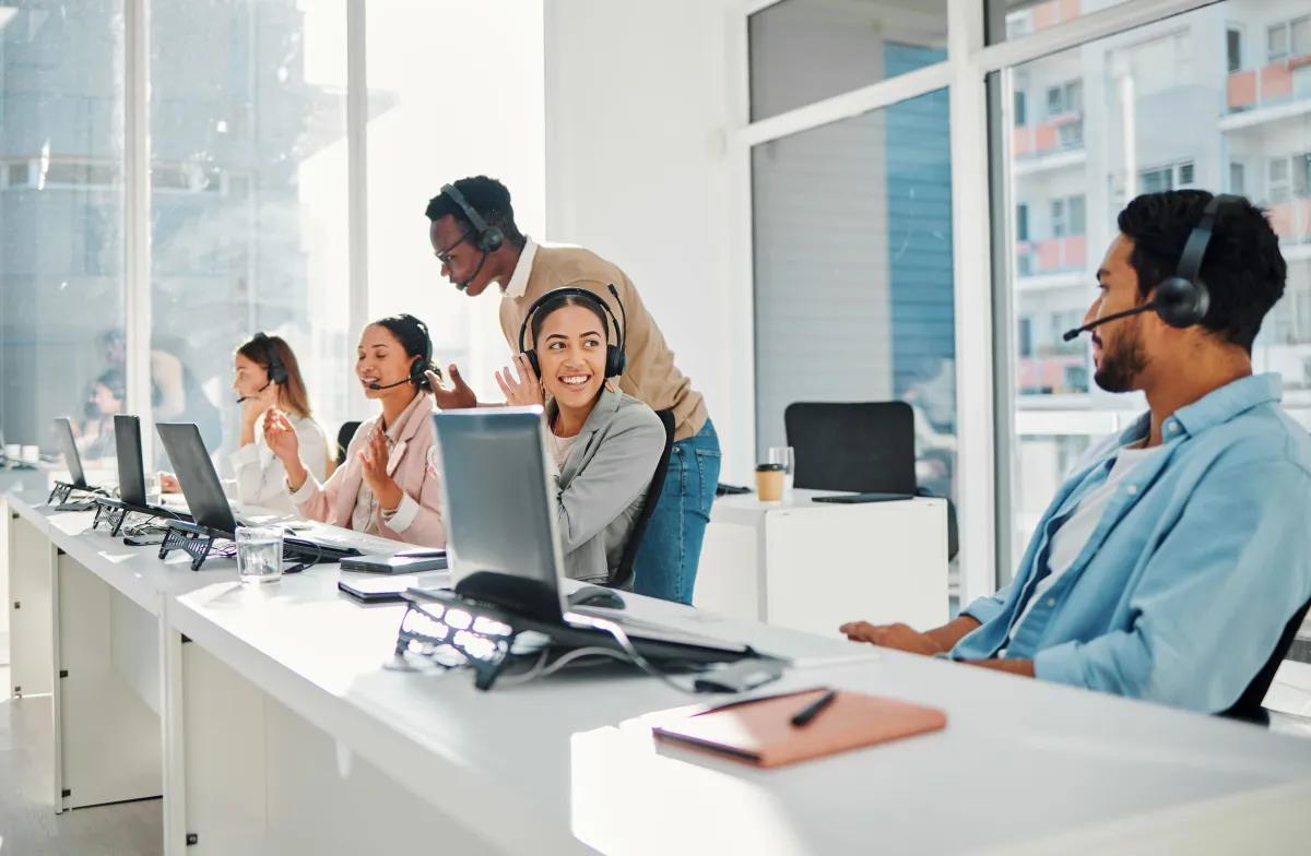 A group of people wearing headsets are working in a call center