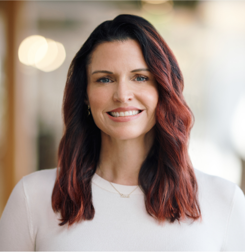 A woman with red hair is wearing a white shirt
