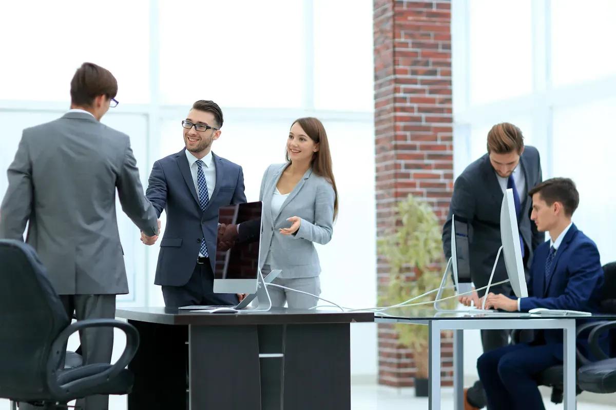 A group of business people are shaking hands in an office