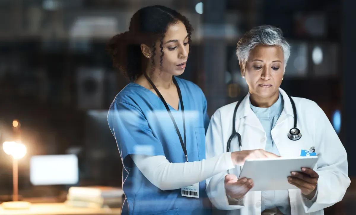 A nurse and a doctor are looking at a tablet together