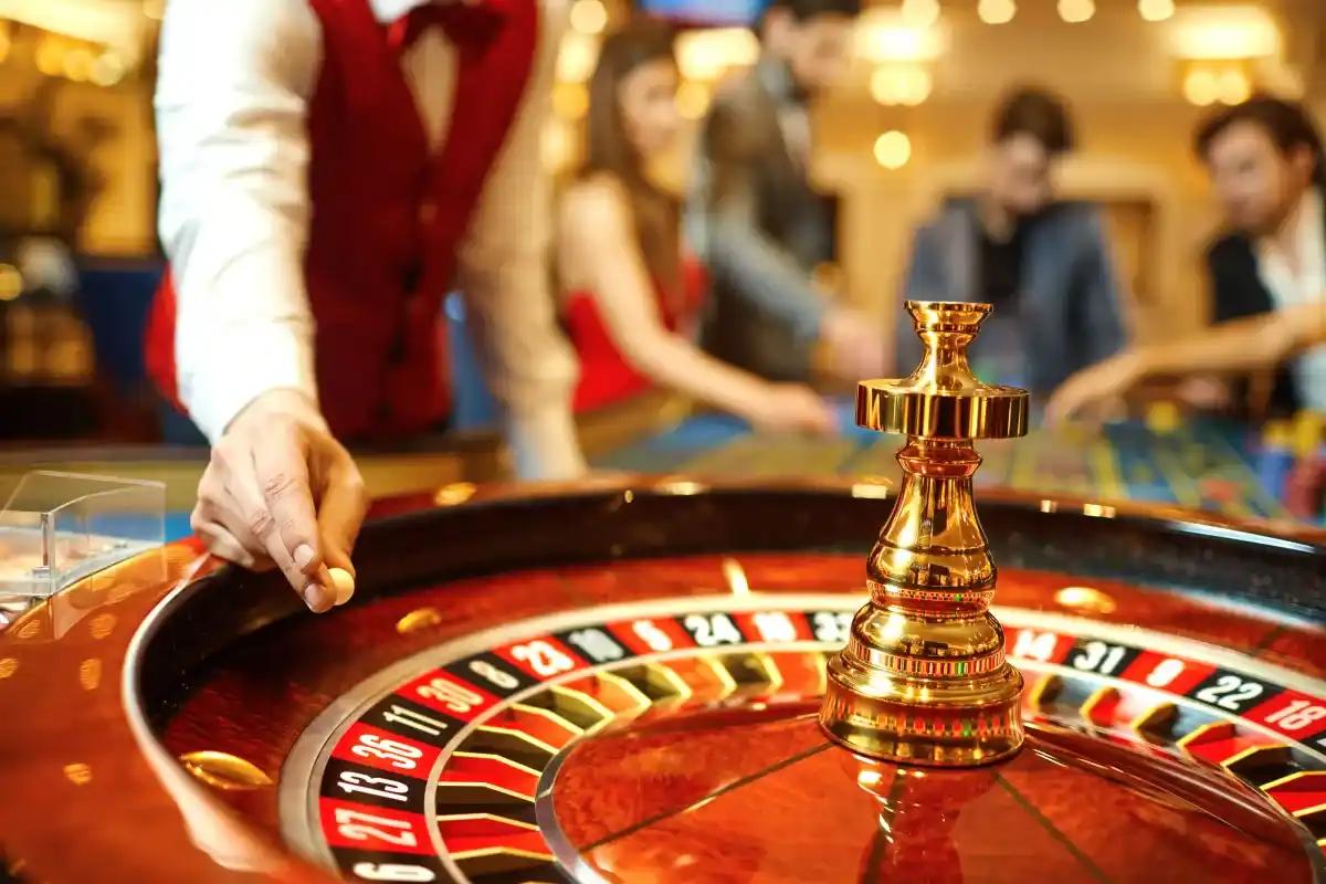 A man is spinning a roulette wheel in a casino