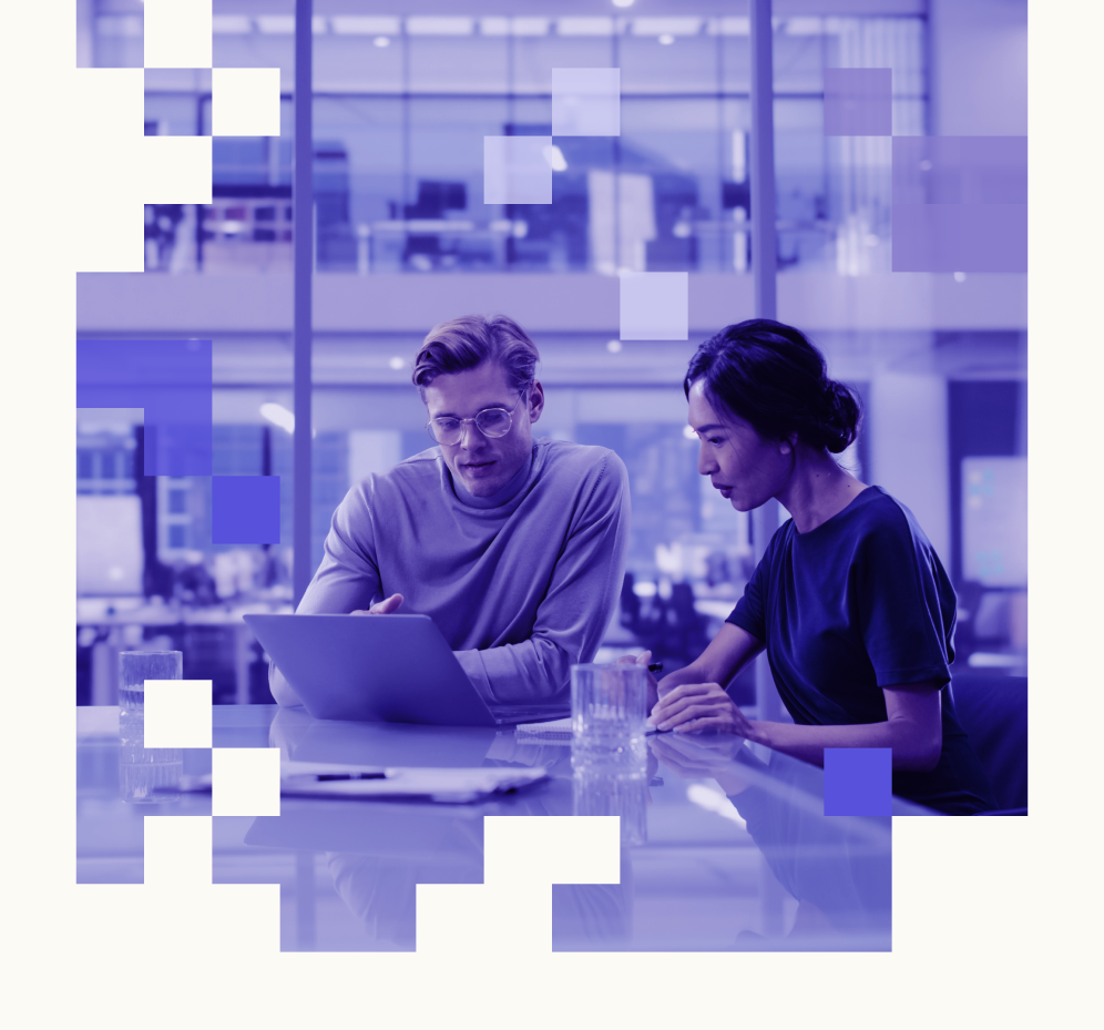 Un uomo e una donna siedono a un tavolo guardando un laptop