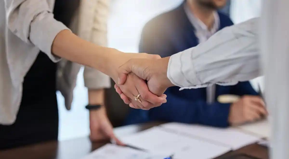 A woman is shaking hands with a man at a table