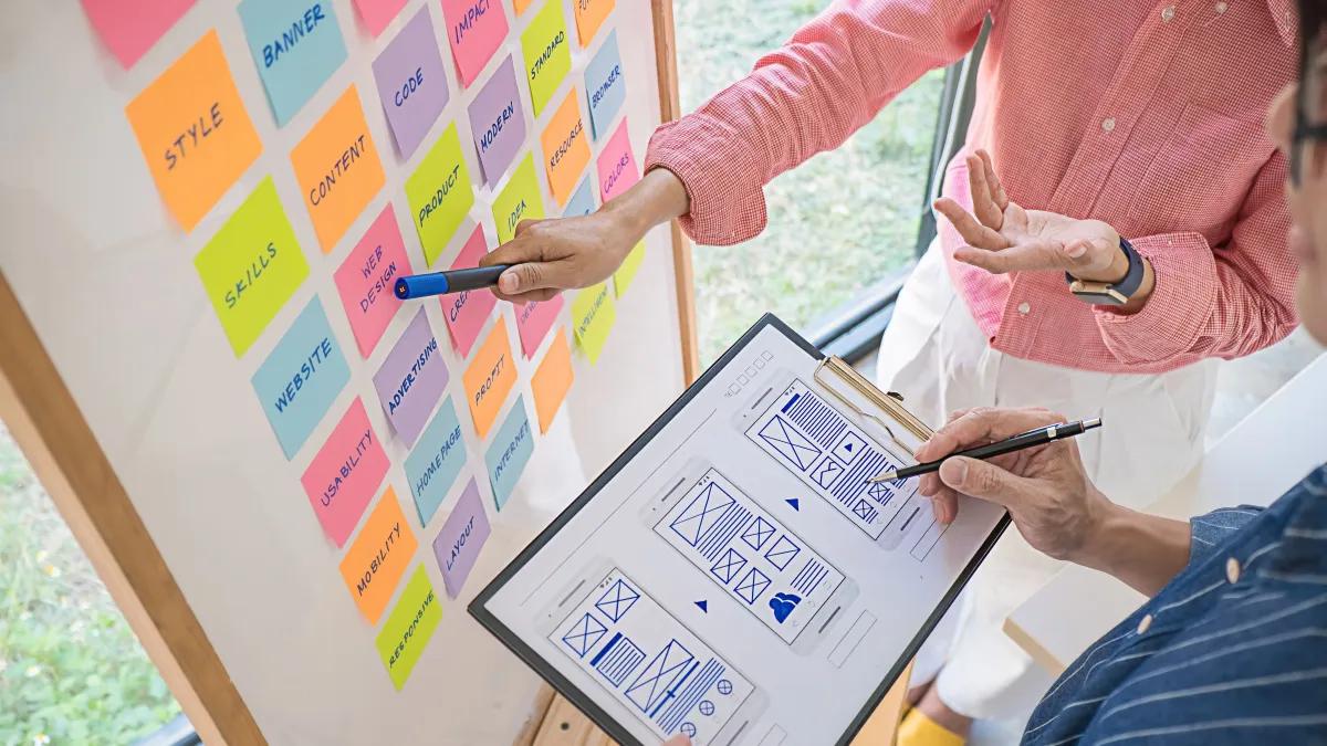 A man and a woman are looking at a clipboard with a diagram on it
