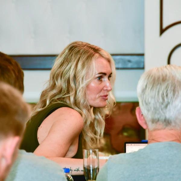 Uma mulher est sentada mesa conversando com um homem