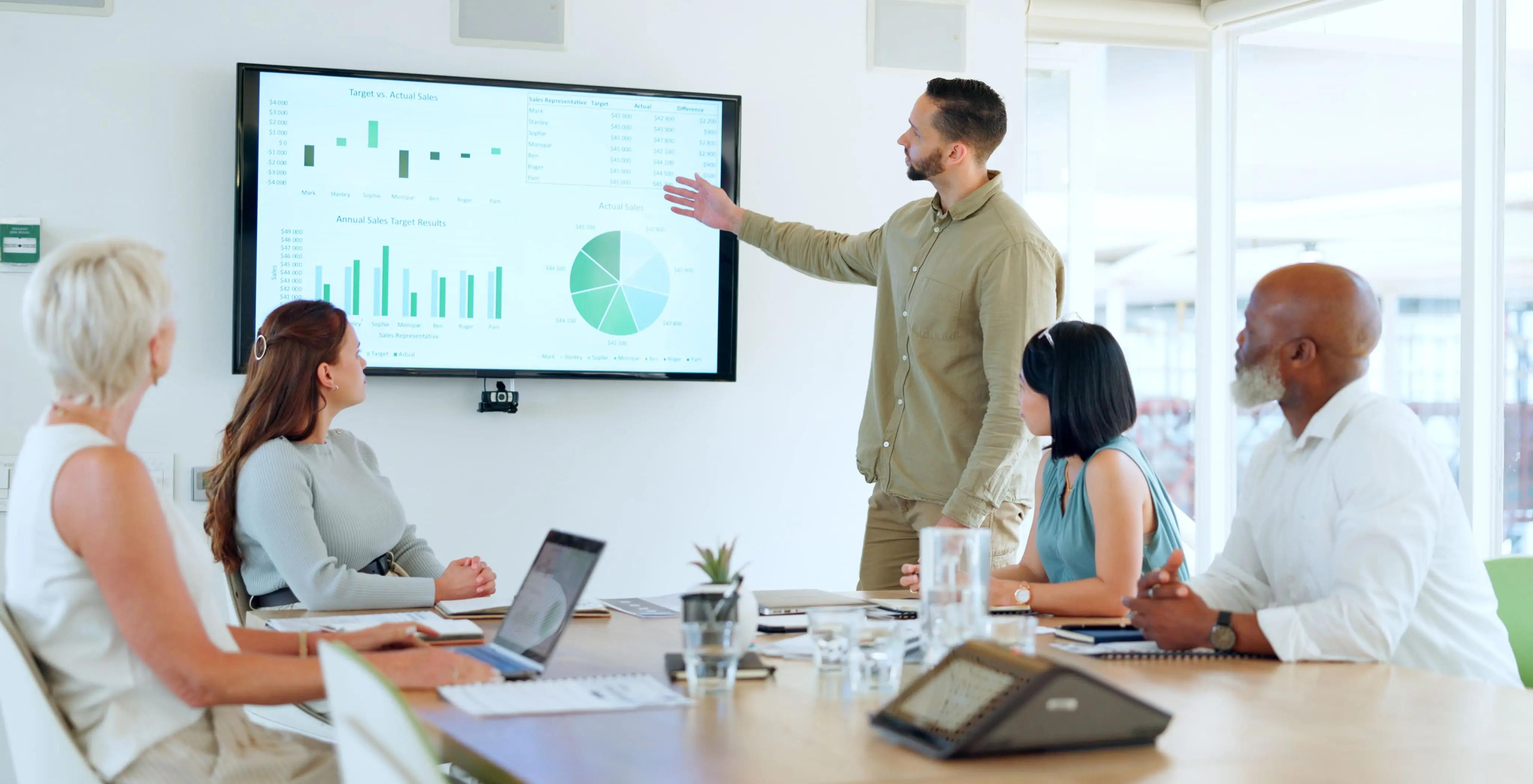 A man is giving a presentation to a group of people in a conference room