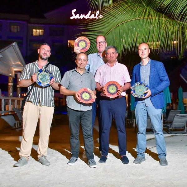 Un groupe dhommes se tient sur une plage tenant des assiettes