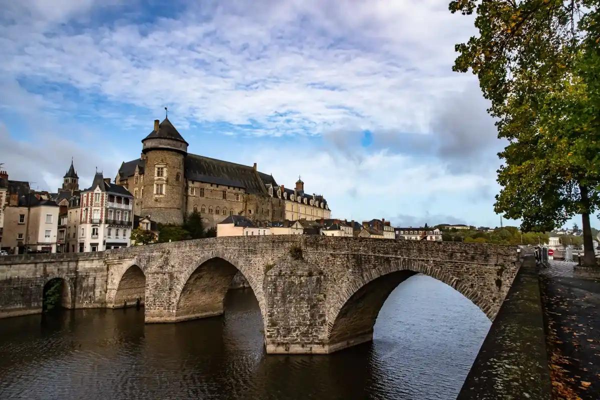 A bridge over a river with a castle in the background
