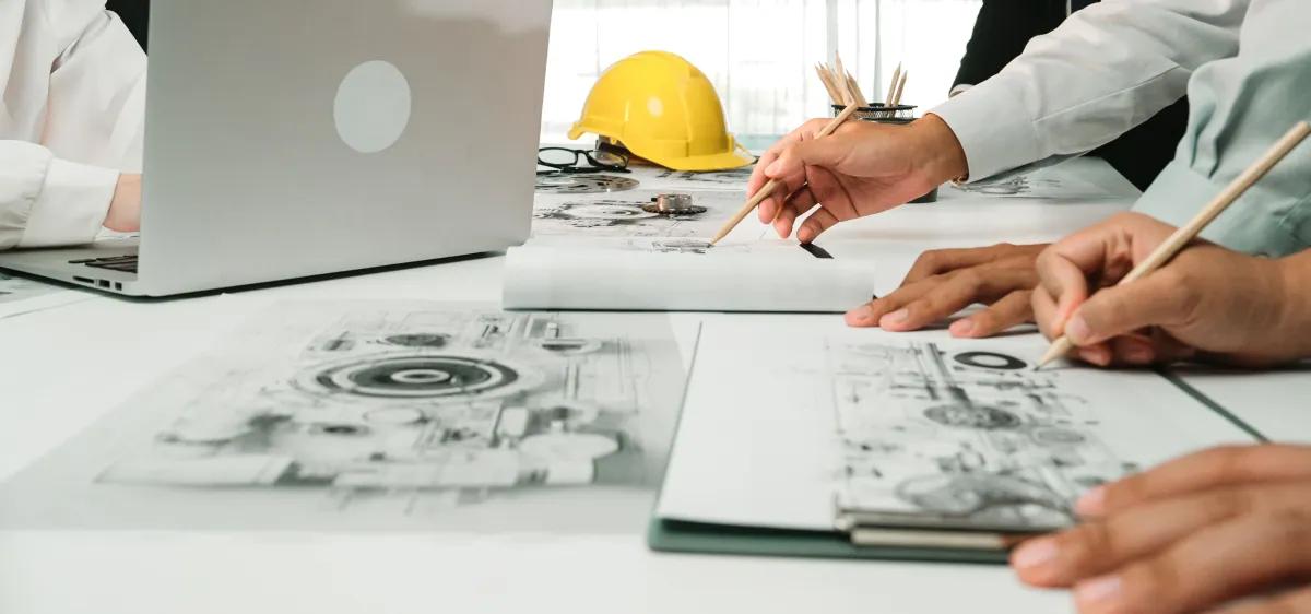 A group of engineers are sitting at a table working on a project