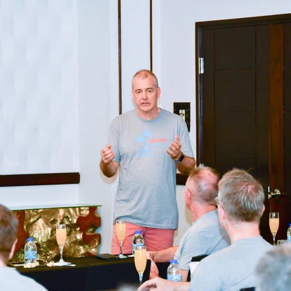 Un homme fait une prsentation un groupe de personnes assises autour dune table