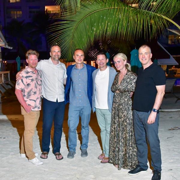 Um grupo de pessoas est posando para uma foto na praia