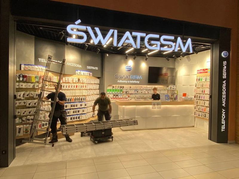 Serwisanci przy montażu kraty rolowanej w salonie ŚwiatGSM
