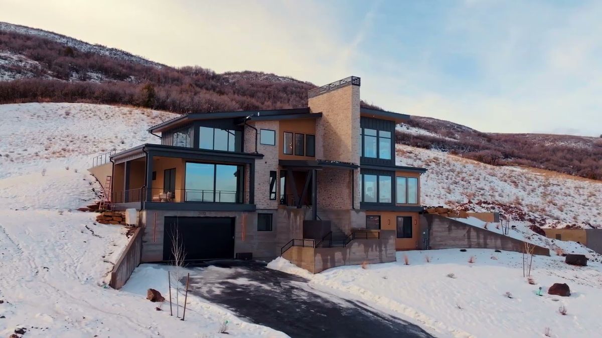 Harris Way, a modern mountain home in winter with stone and wood facade, Heber Valley, Utah