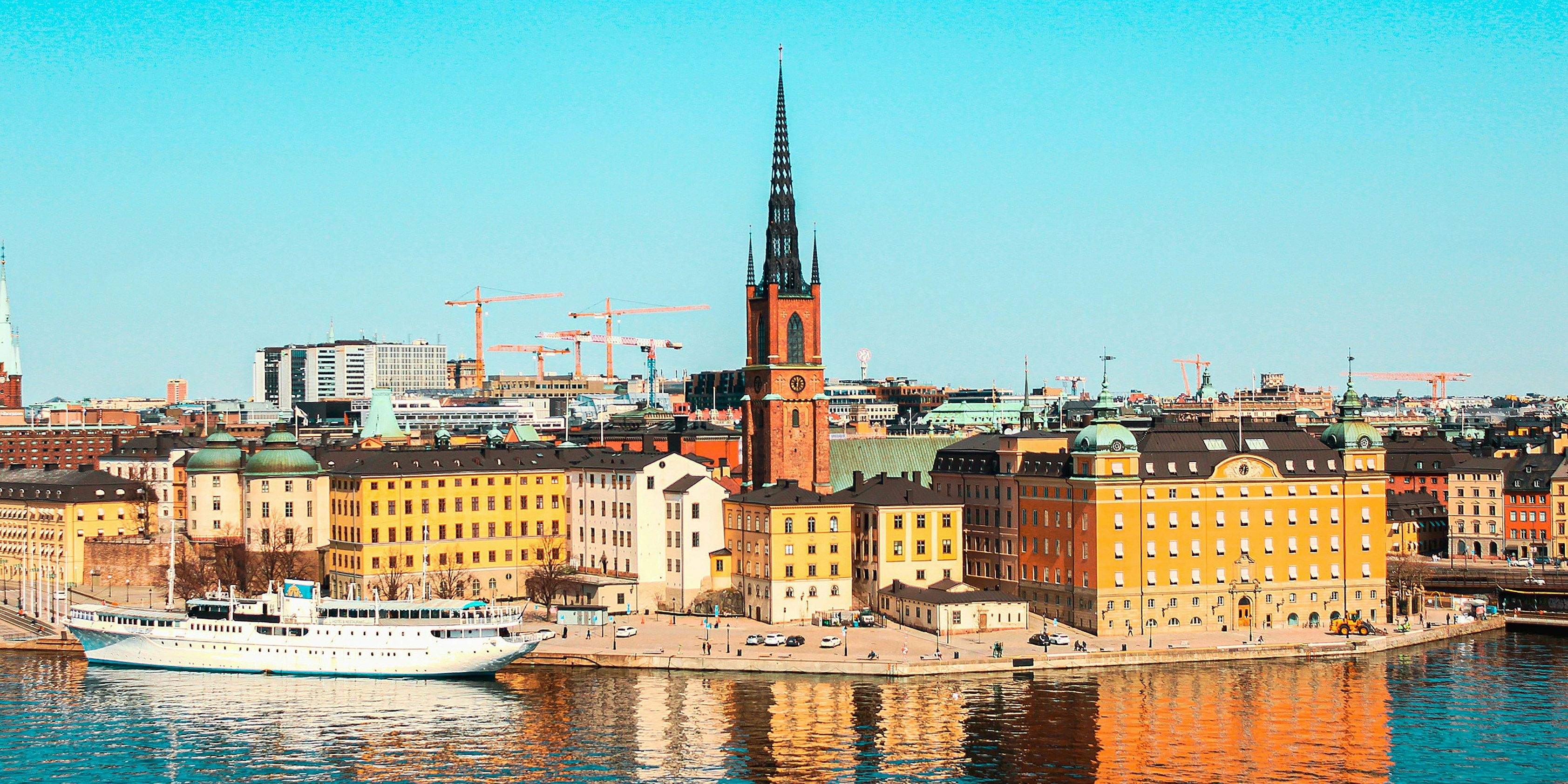 a boat is floating on the water in front of a city .