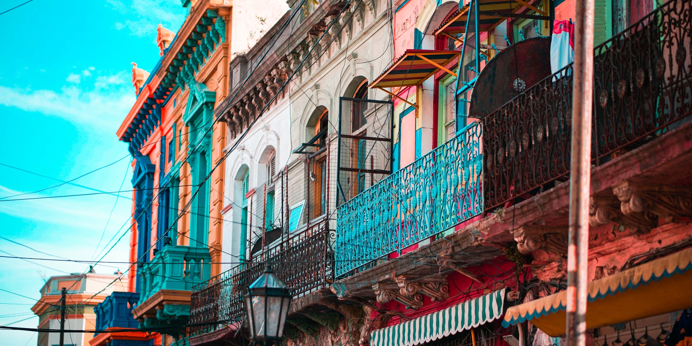 a row of colorful buildings with balconies including one that says ' a ' on it