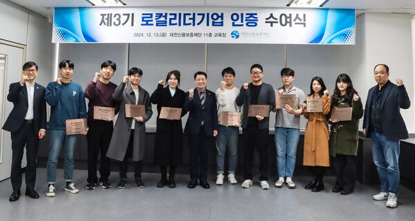 대전신용보증재단 본점에서 열린 '제3기 로컬리더기업 인증 수여식'에서 양필환 이사장과 주식회사 워코 임용묵 대표를 비롯한 12개 인증 기업 대표들이 현판을 들고 기념 촬영을 하고 있는 모습.