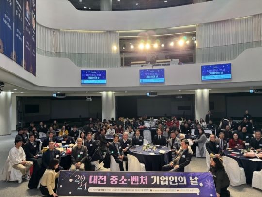 '2024 대전 중소·벤처기업인의 날' 유공자 포상 시상식에서 대덕이노폴리스벤처협회장 표창을 수상한 주식회사 워코 임용묵 대표를 비롯한 수상자들이 상패를 들고 단상 위에서 기념 촬영을 하는 모습.