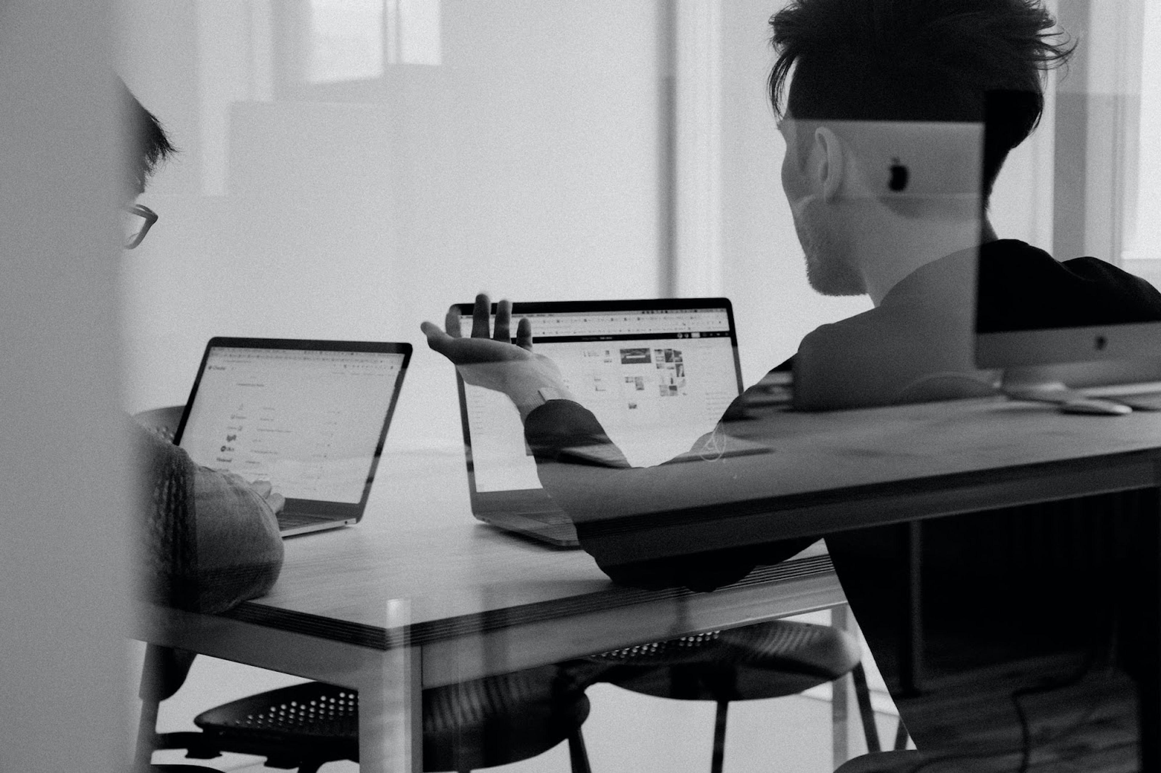 Team discussion with laptops in a modern office setting