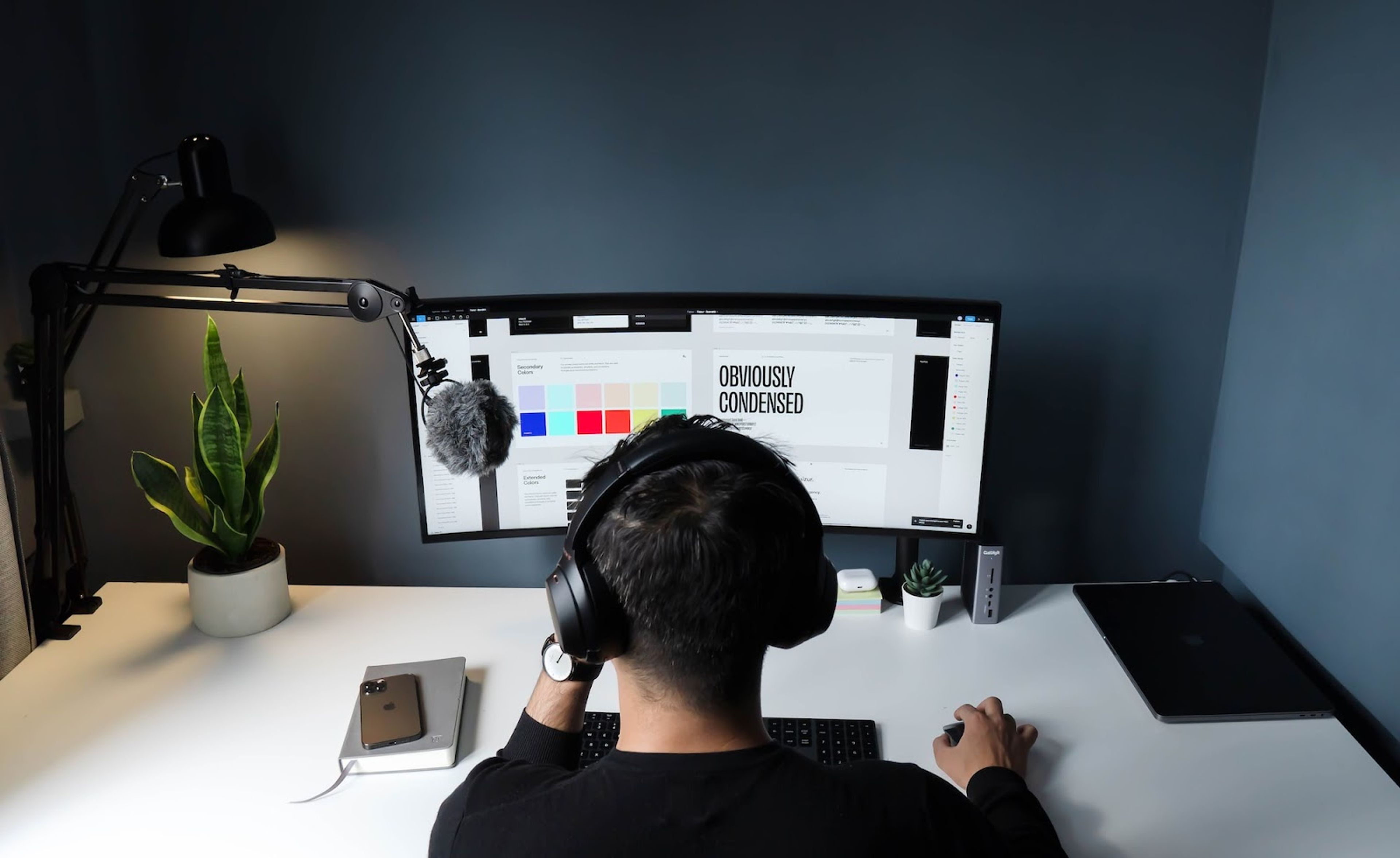 Designer working on a dual-monitor setup in a minimalist workspace