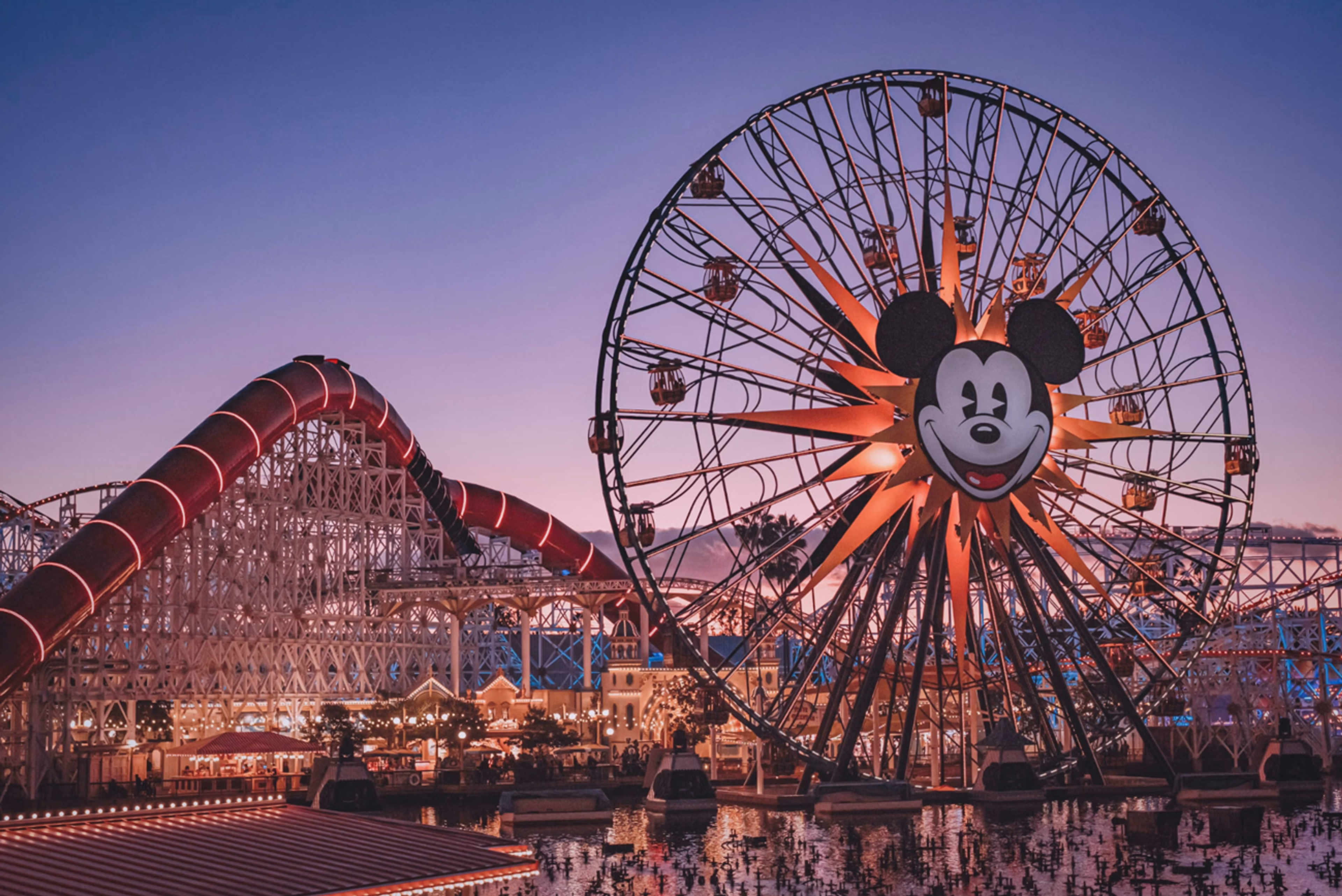 Amusement park at sunset with iconic Ferris wheel