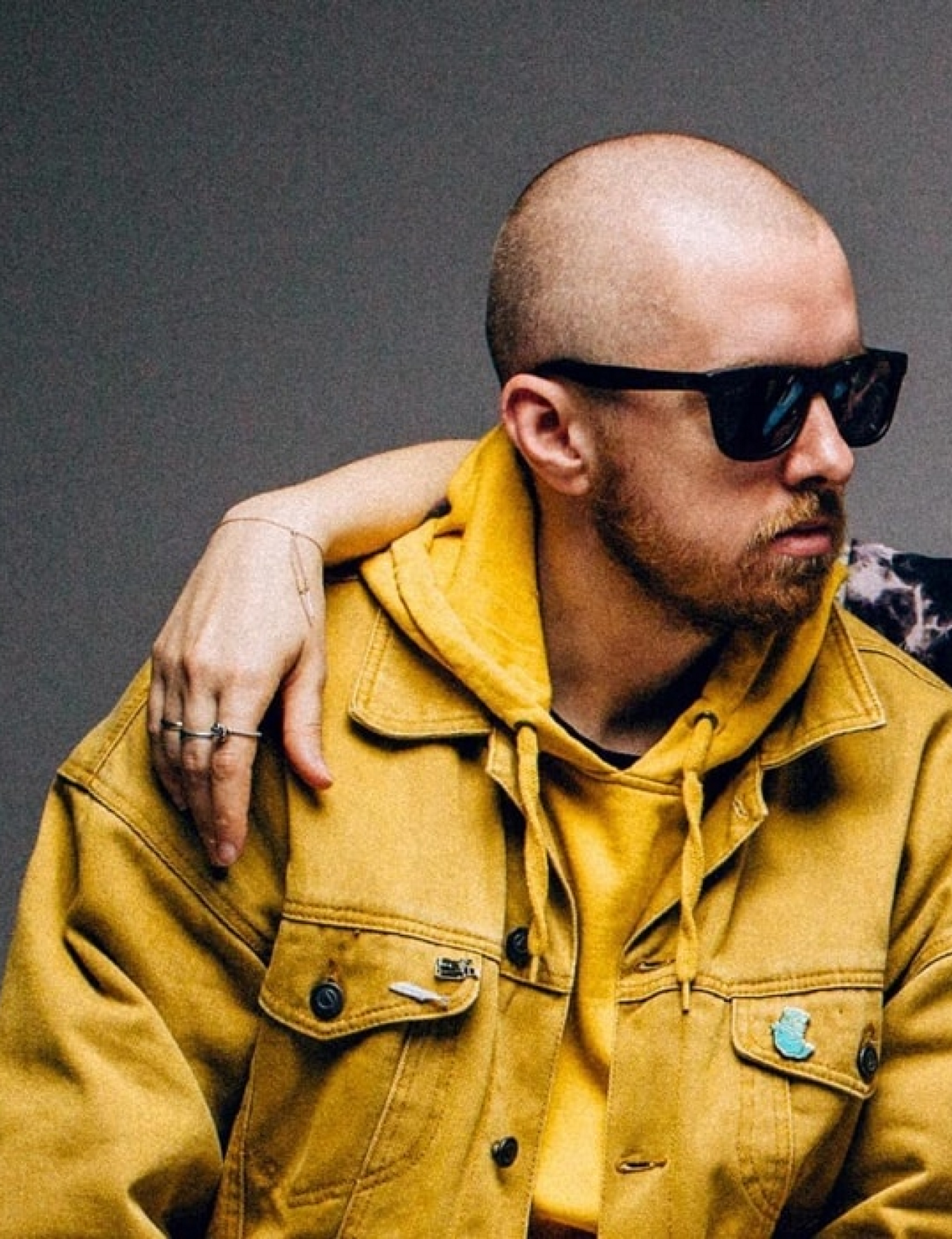 a person wearing sunglasses and a yellow jacket