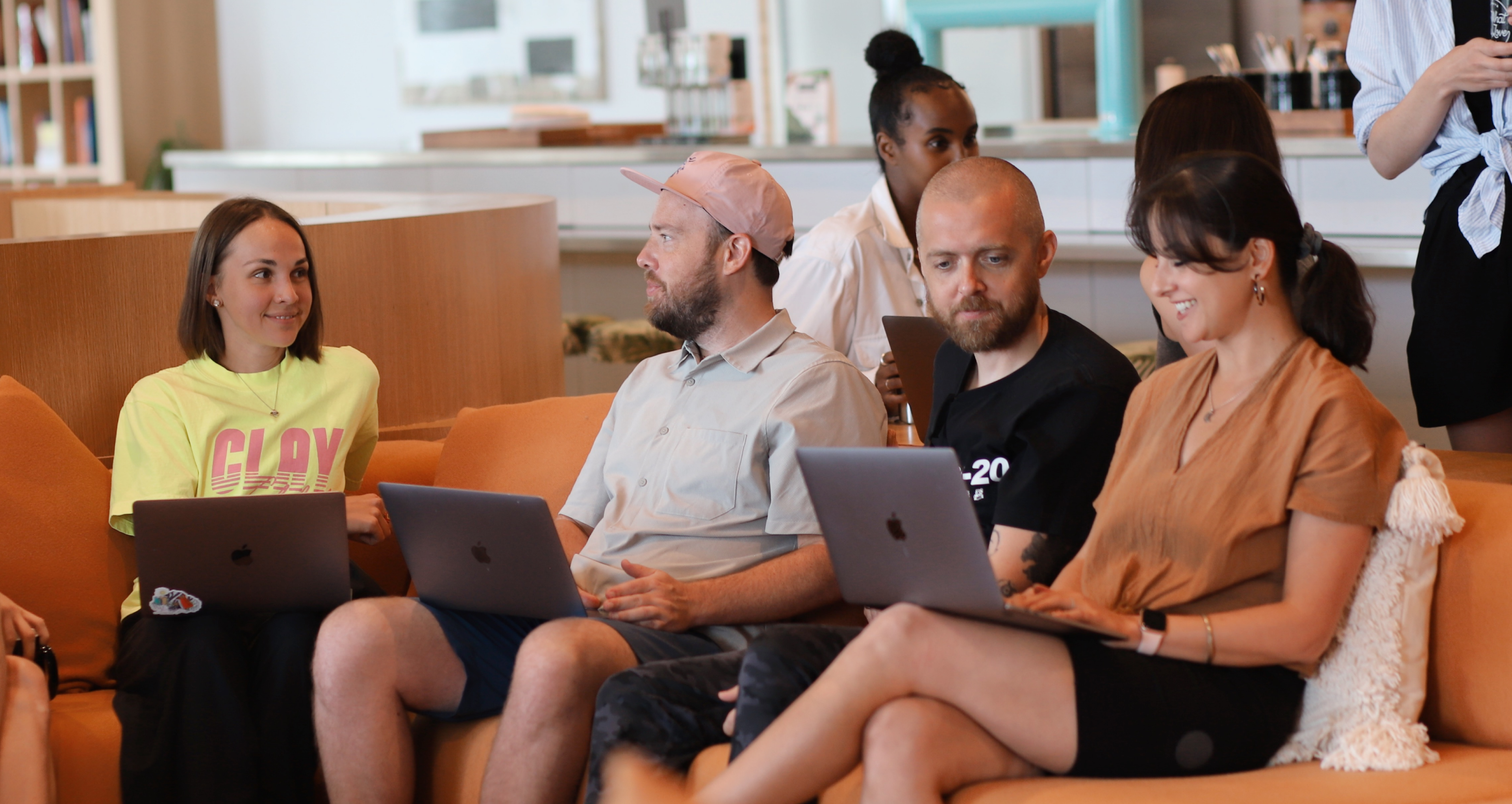a group of Clay team members sitting on a couch with laptops