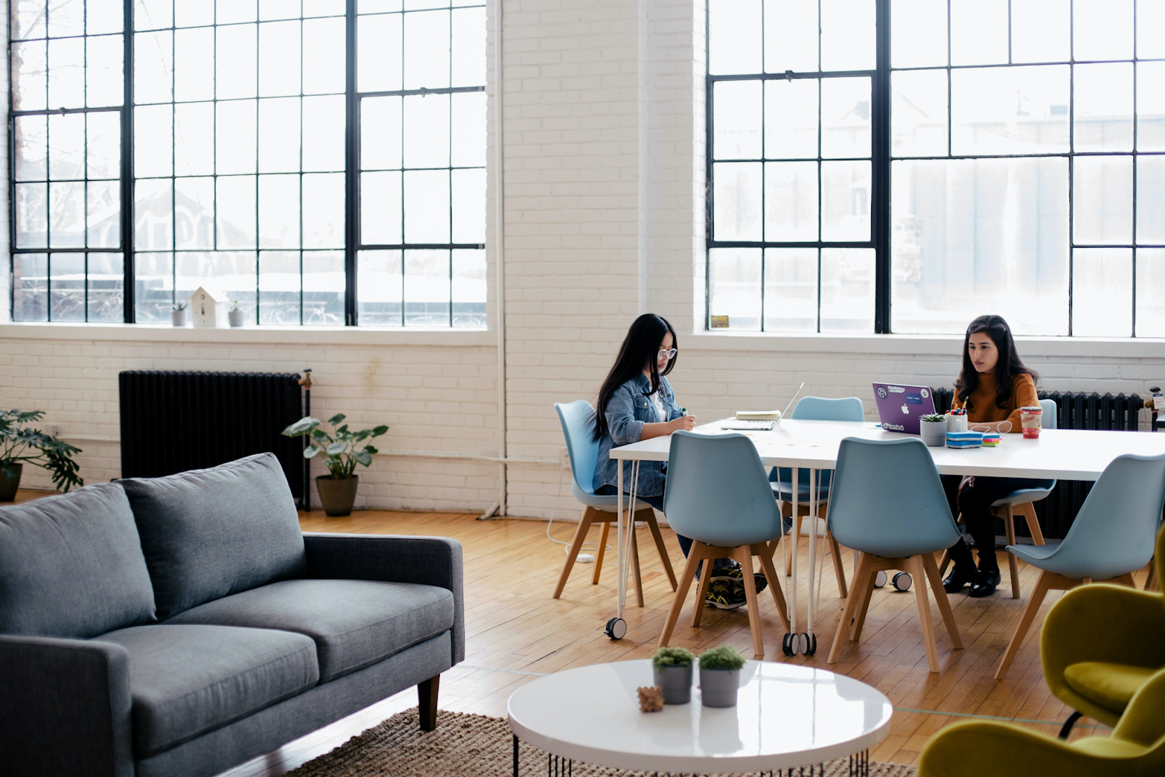 Two women working at a spacious office 