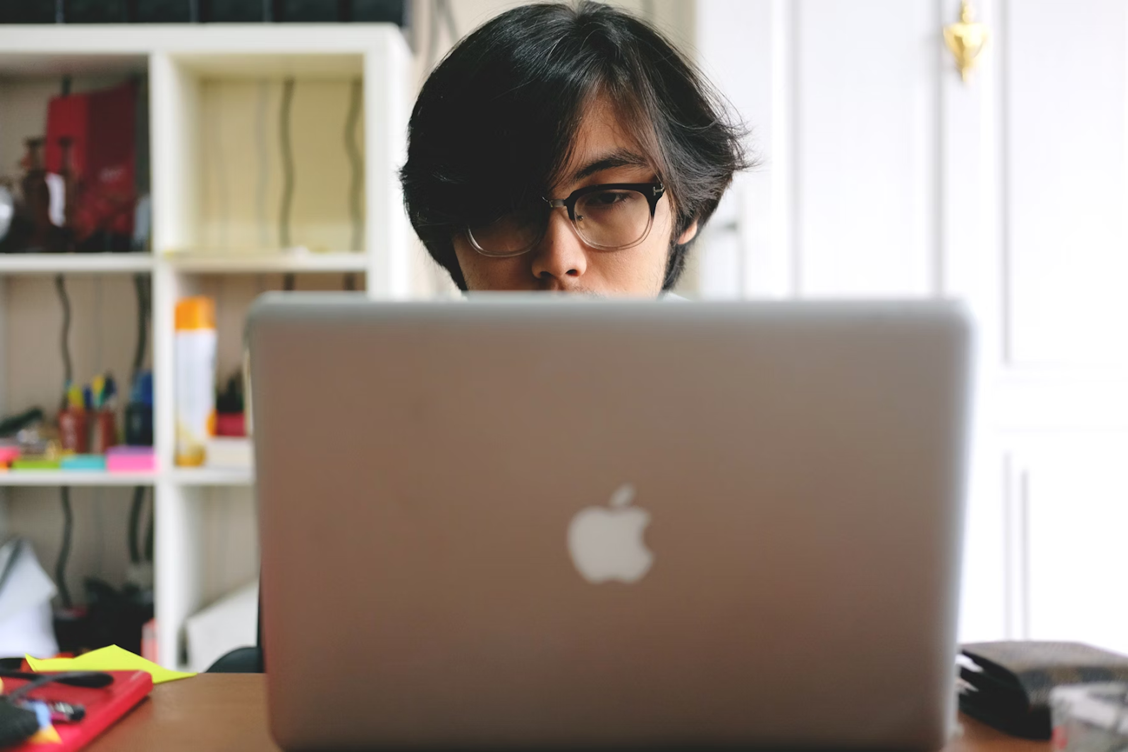 A person focused on working with a laptop at a desk