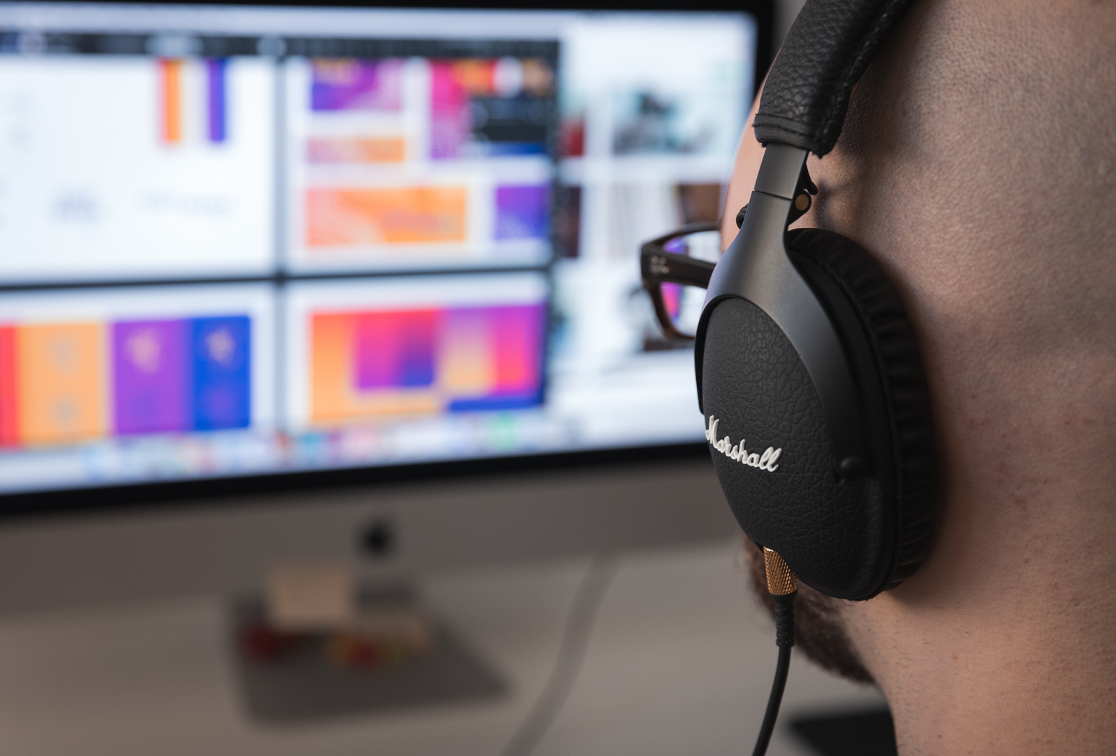 A man wearing headphones looking at a monitor