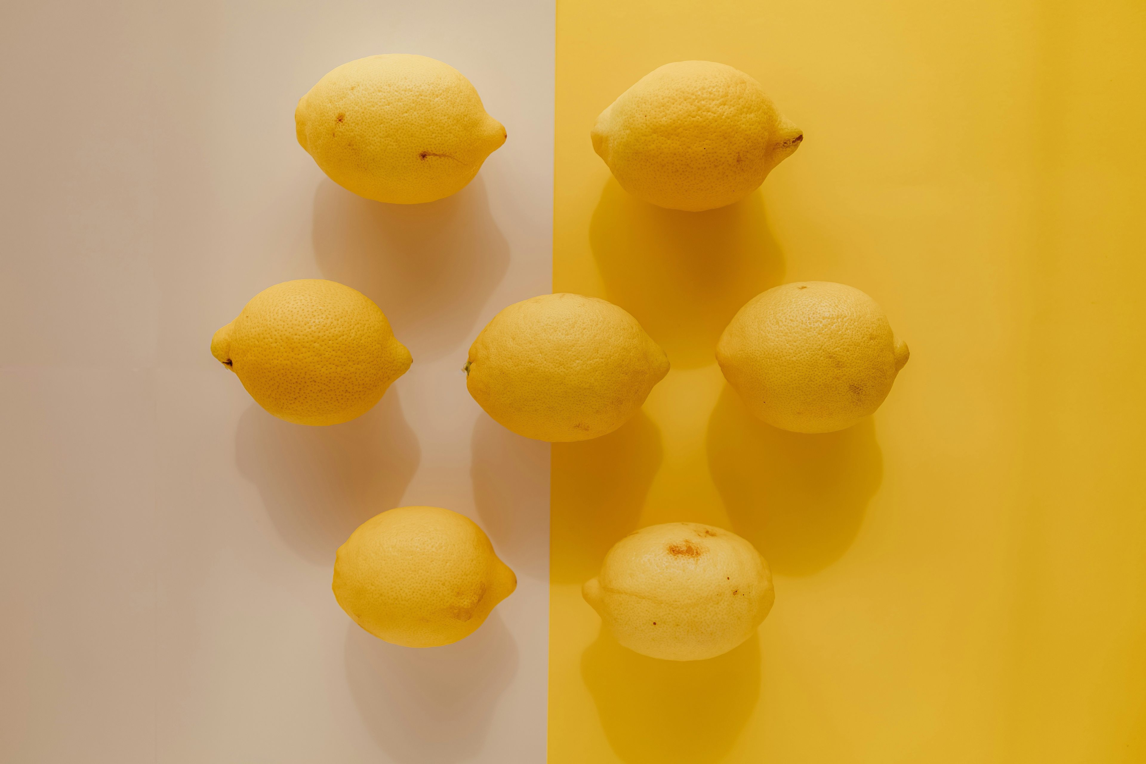 Eight lemons on white-yellow background