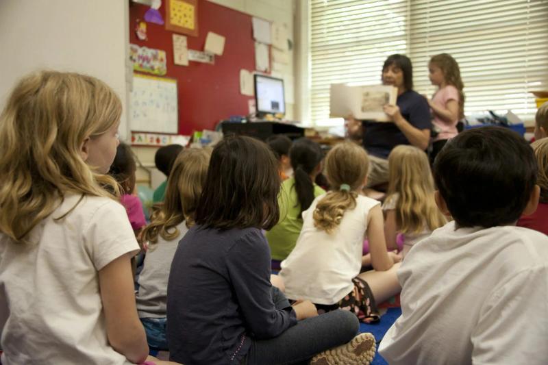 Kids sitting on the floor of a classroom