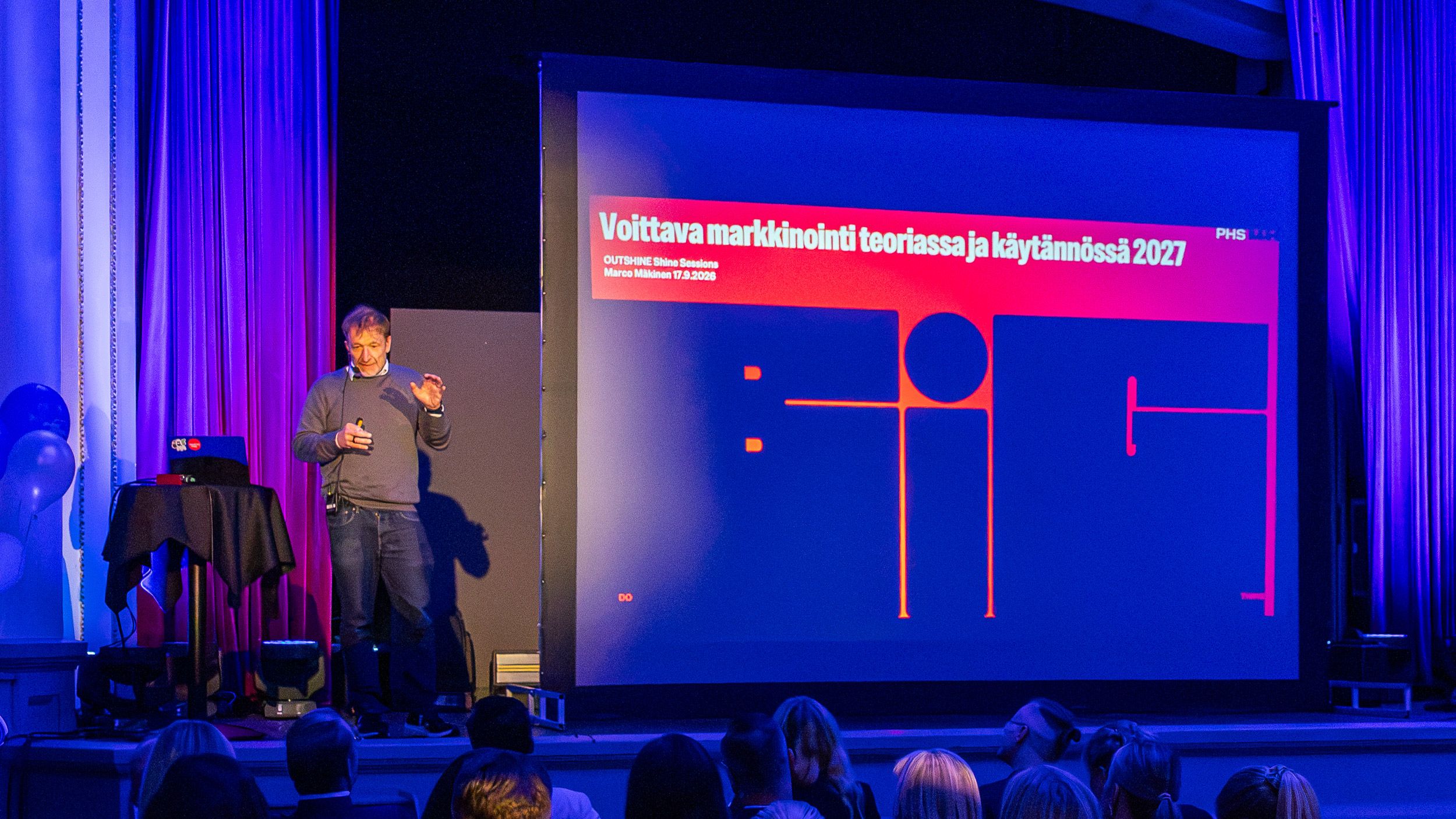 Marco Mäkinen esiintymässä Shine Sessions -tapahtumassa lavalla esitellen voittavaa markkinointia vuonna 2027.