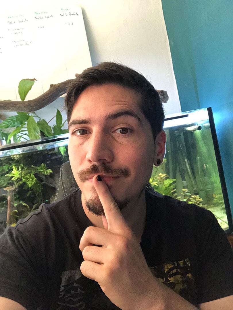 man sitting down in front of a fish tank