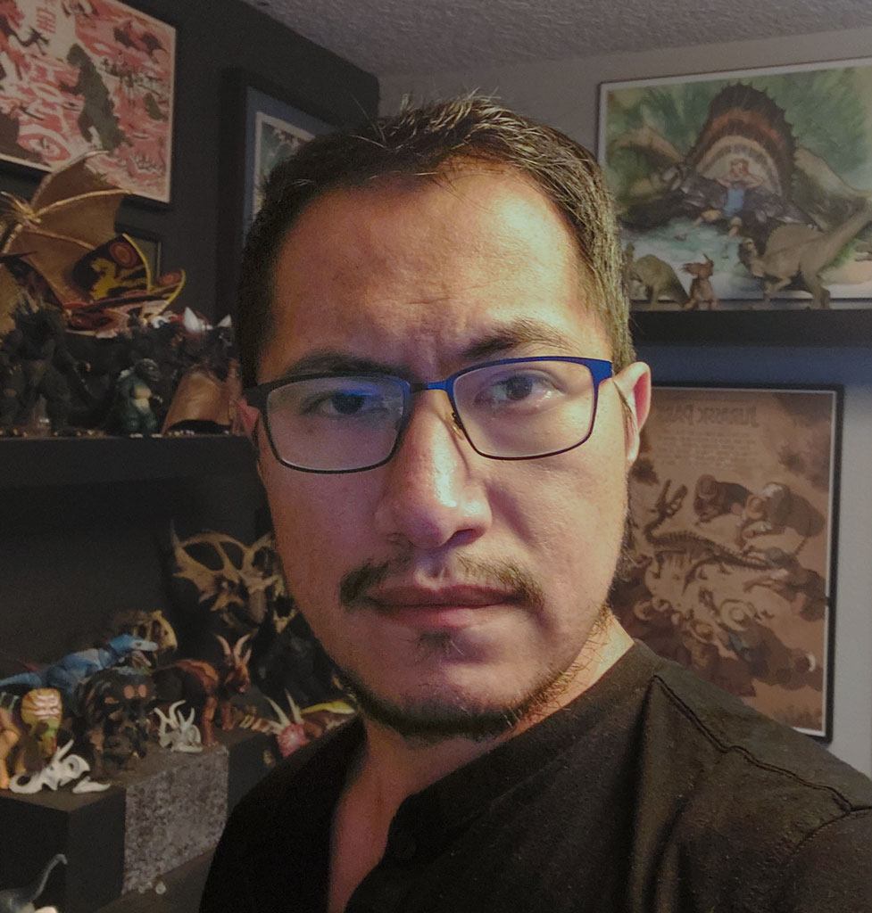 portrait of a man in his office in front of various pieces of dinosaur art