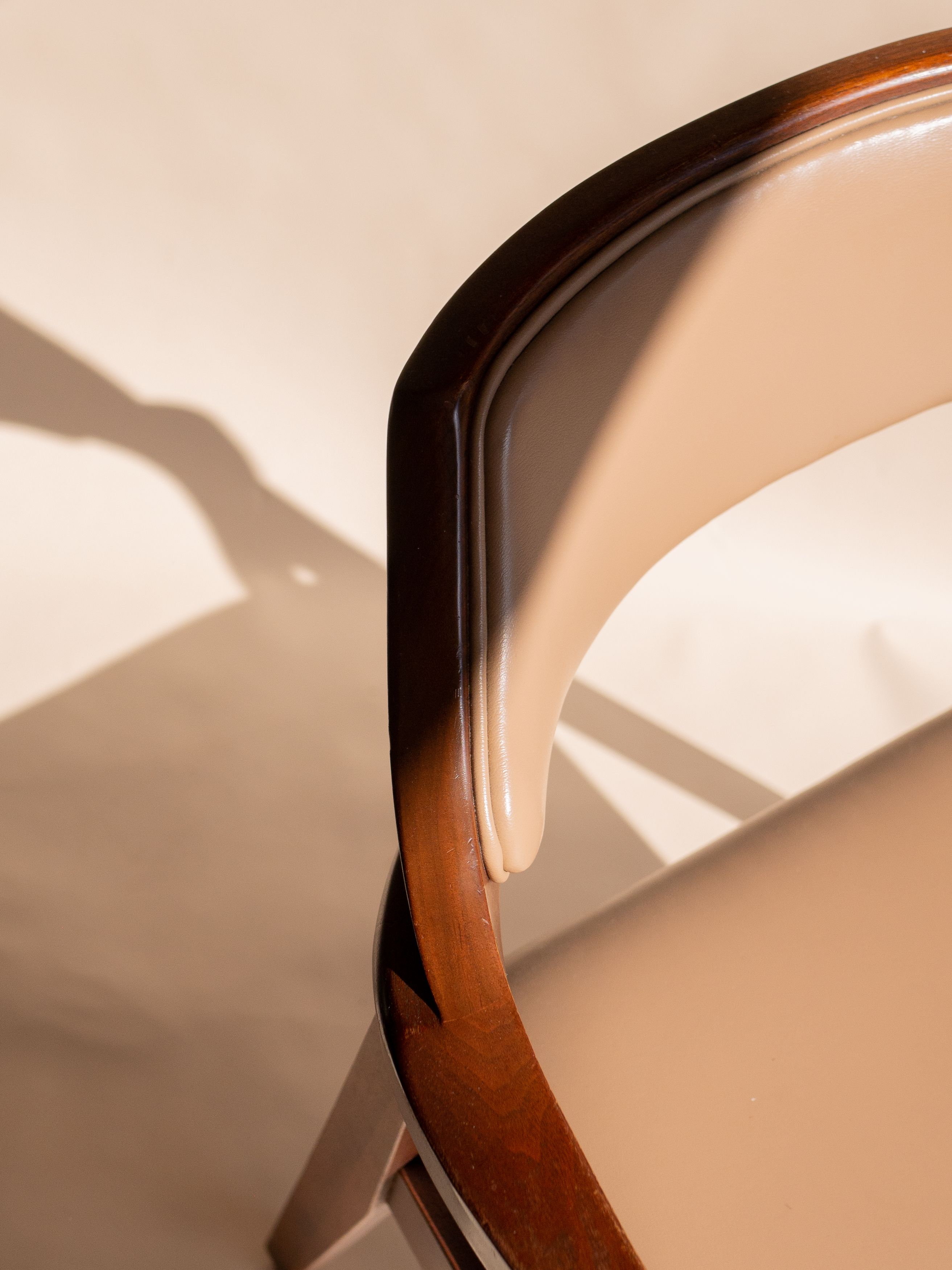 A close up of a formal chair casting a shadow onto the ground