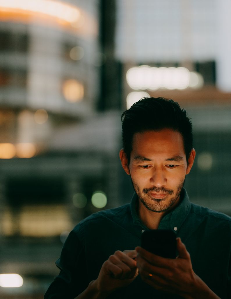 A businessman reading his phone in a city office