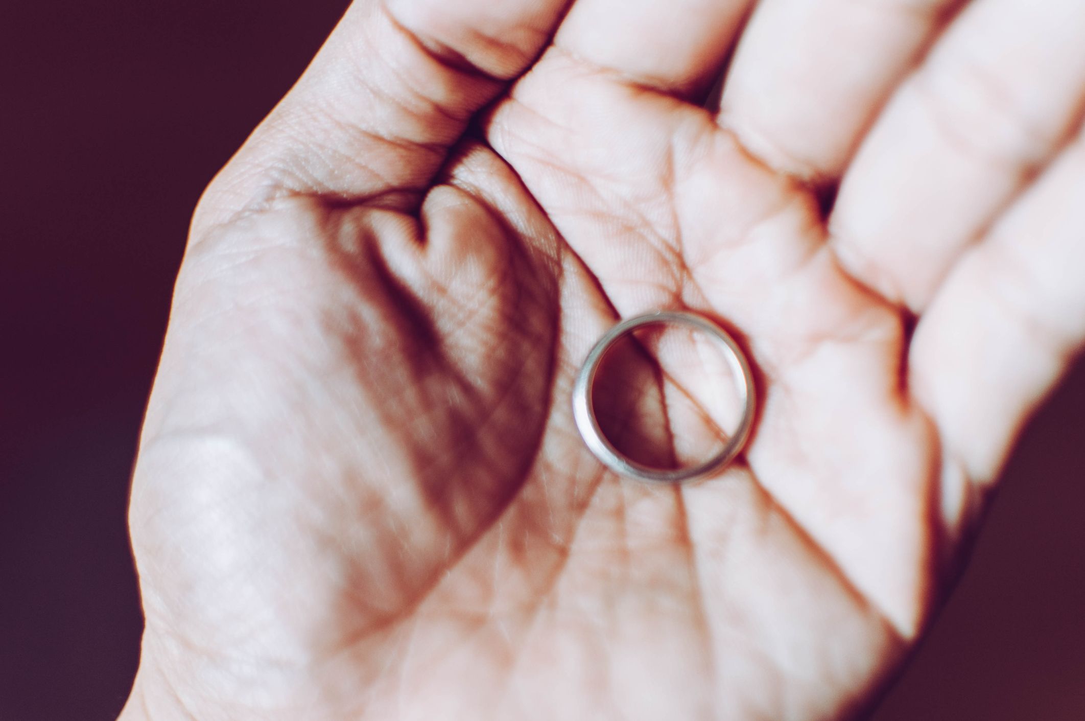 Close up of a wedding ring on the palm of a person's hand