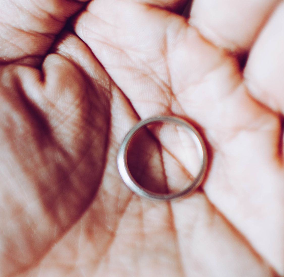 Close up of a wedding ring on the palm of a person's hand