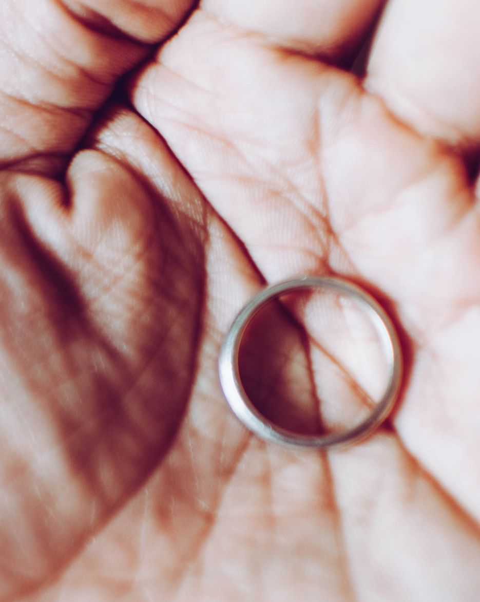 Close up of a wedding ring on the palm of a person's hand