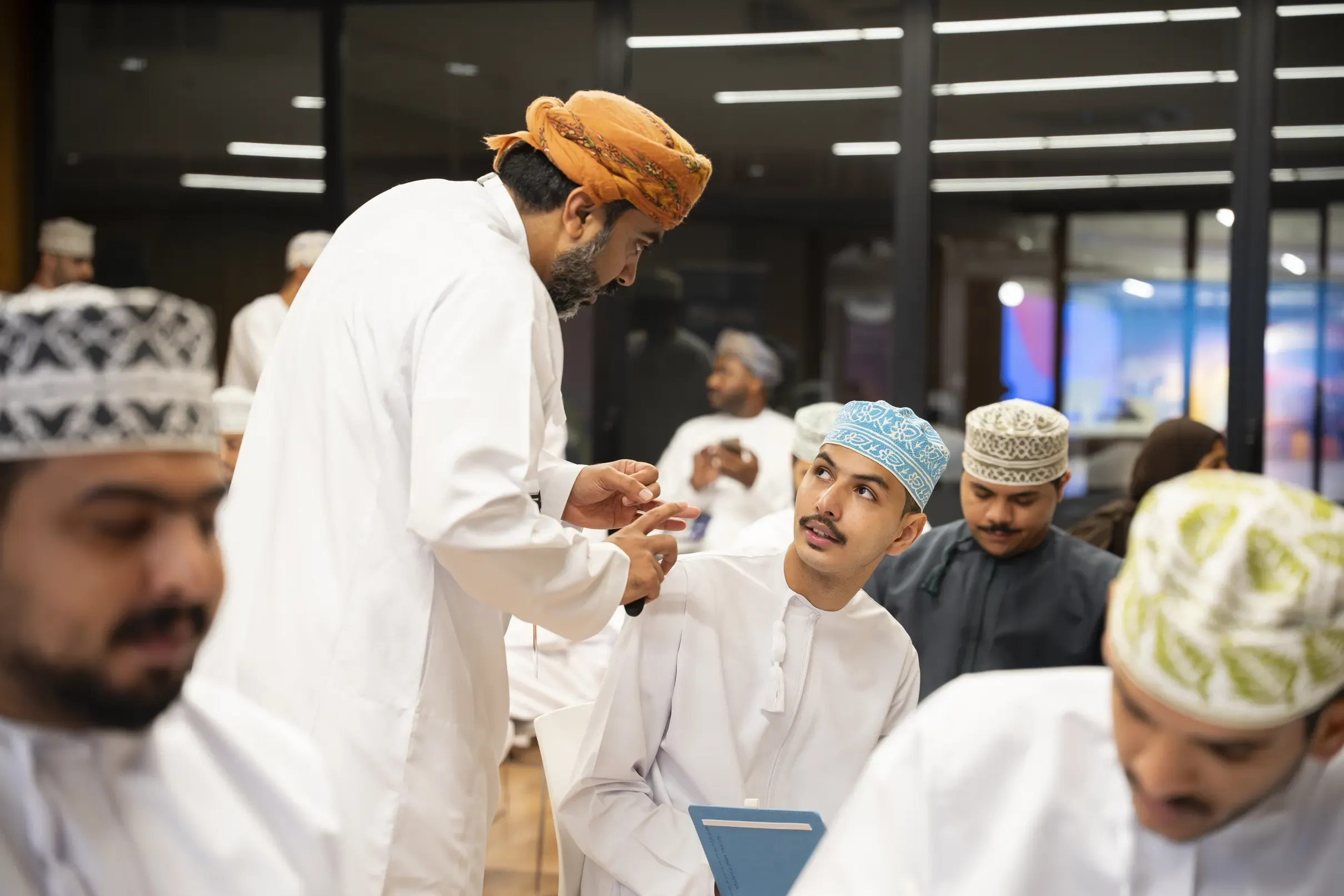 A mentor leaning into a table of participants
