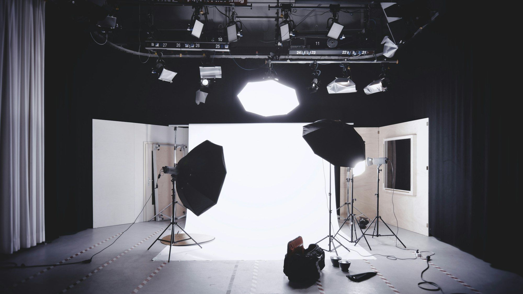 A photography studio with two large octagonal softboxes and an overhead light rig aimed at a white background