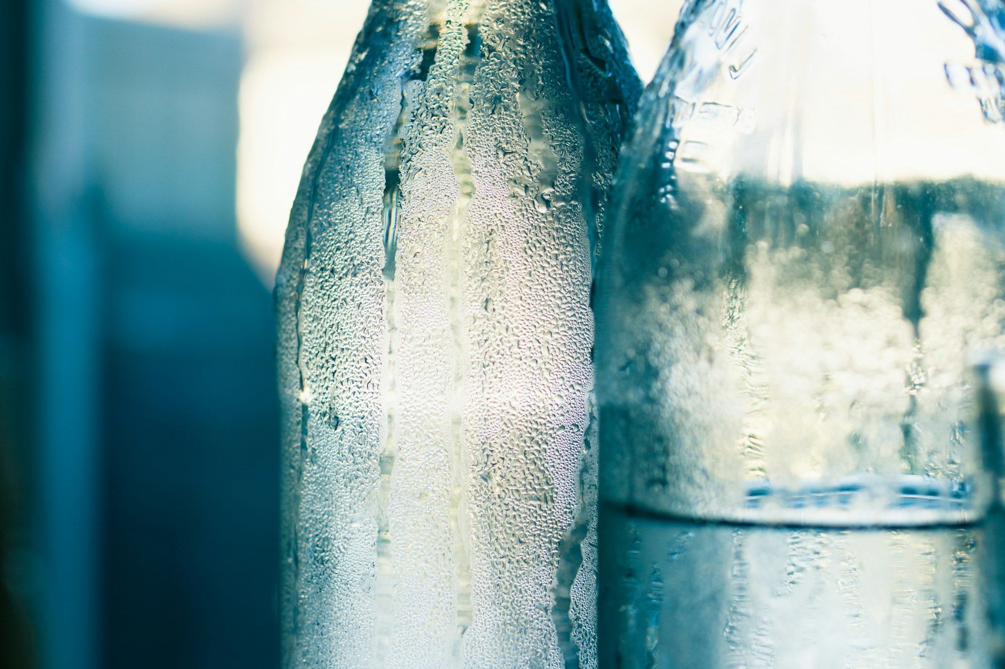 Condensation running down the sides of two cold glass bottles