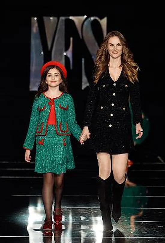 Karina Moisieieva, representative of Mia Belle Girls, walking the YFS runway with a young model