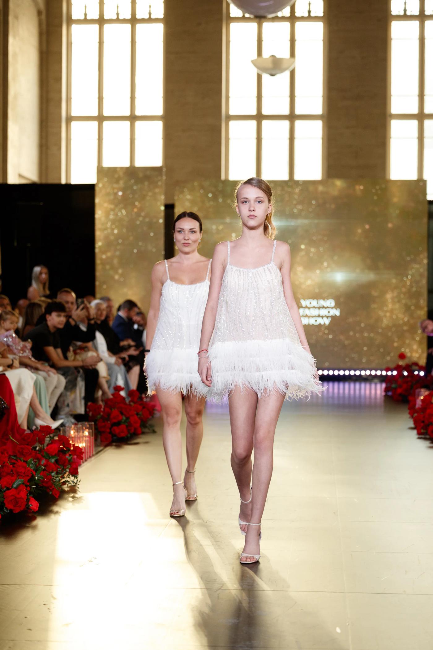 Two models in white walking the YFS runway together