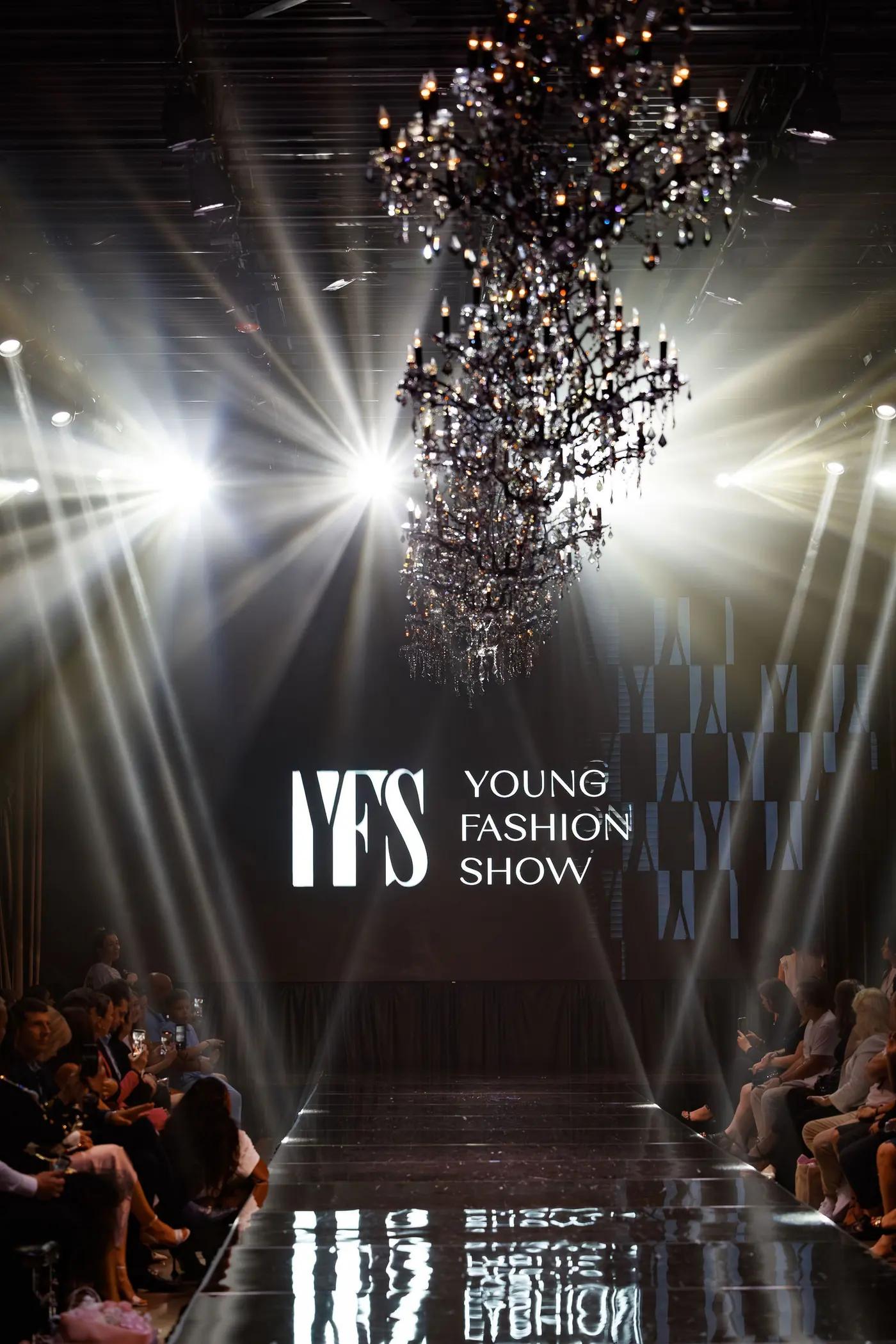 Runway under a chandelier and stage lights at a YFS show