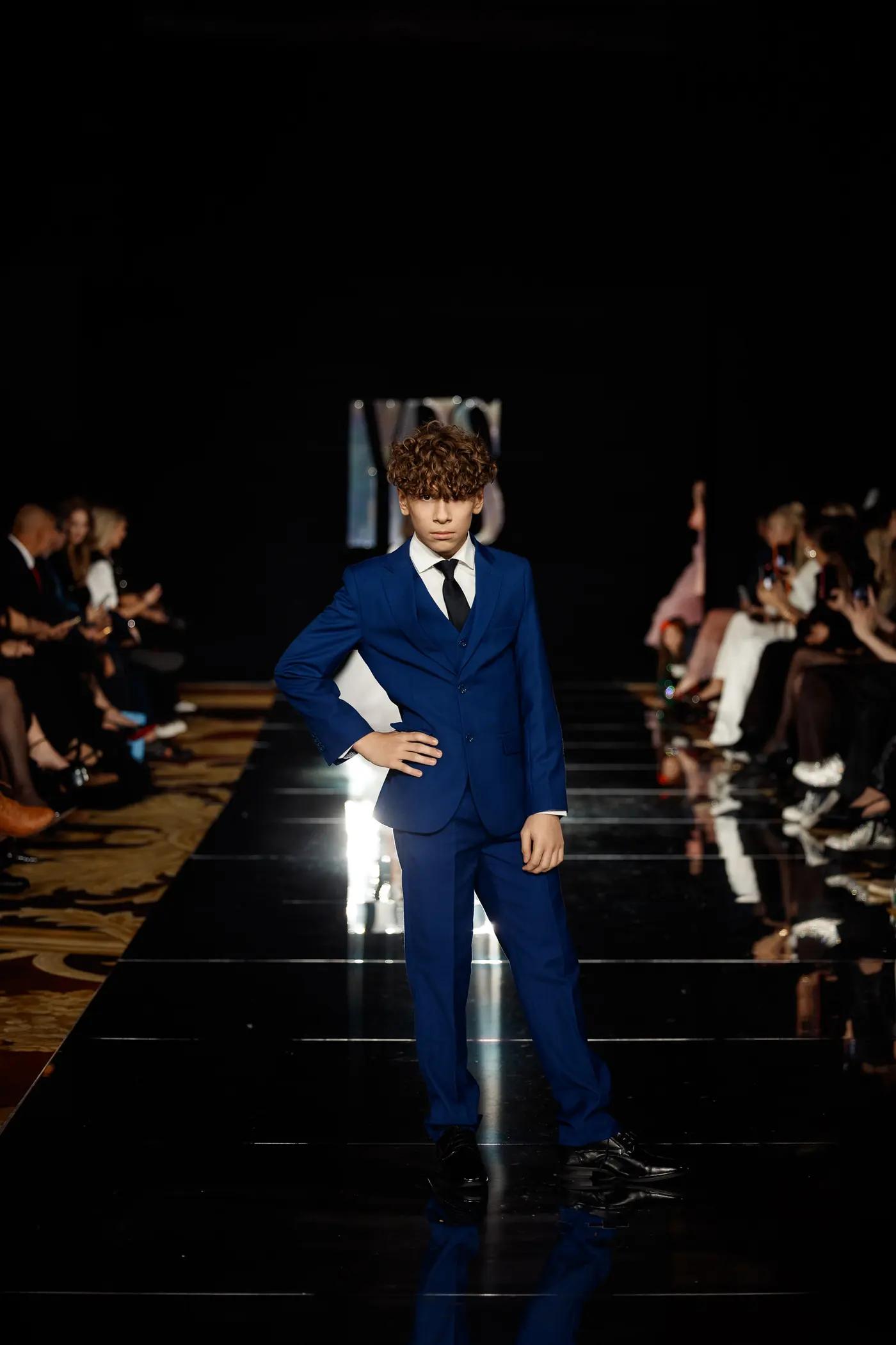 Boy in a navy suit on the runway