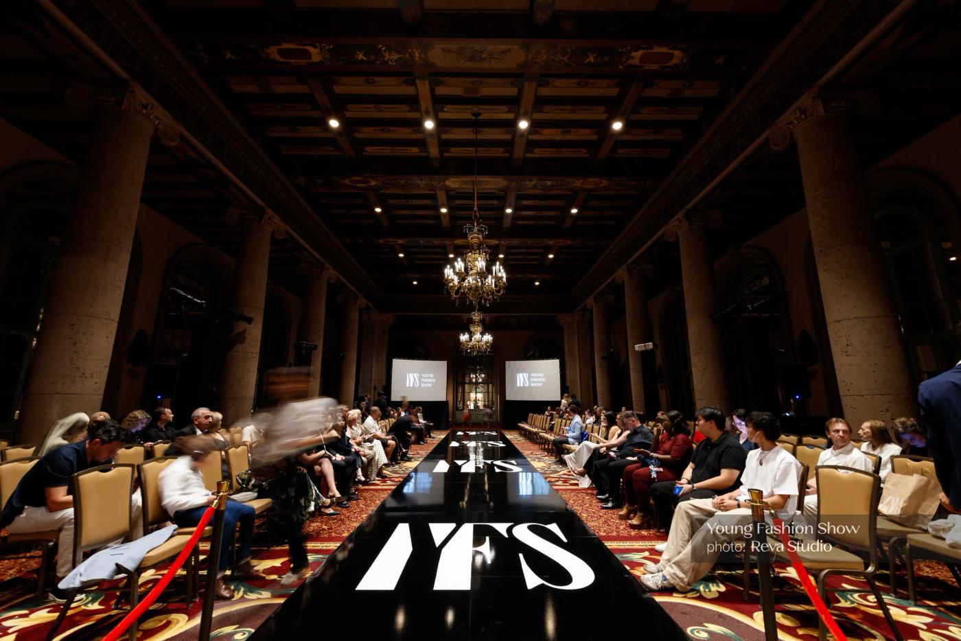 Wide view of a YFS venue with the runway and seated audience