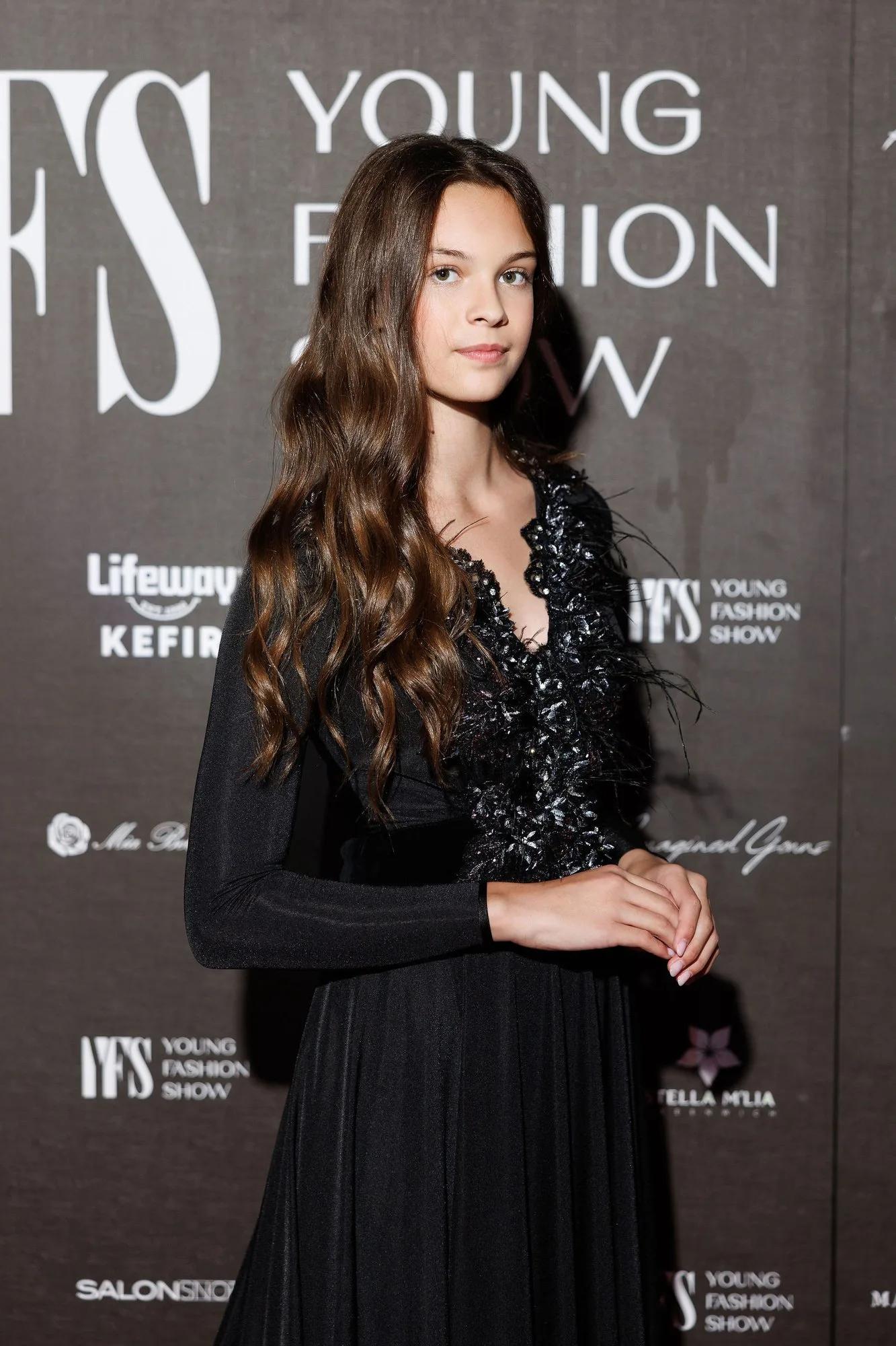 A guest at the YFS step-and-repeat wall with partner logos
